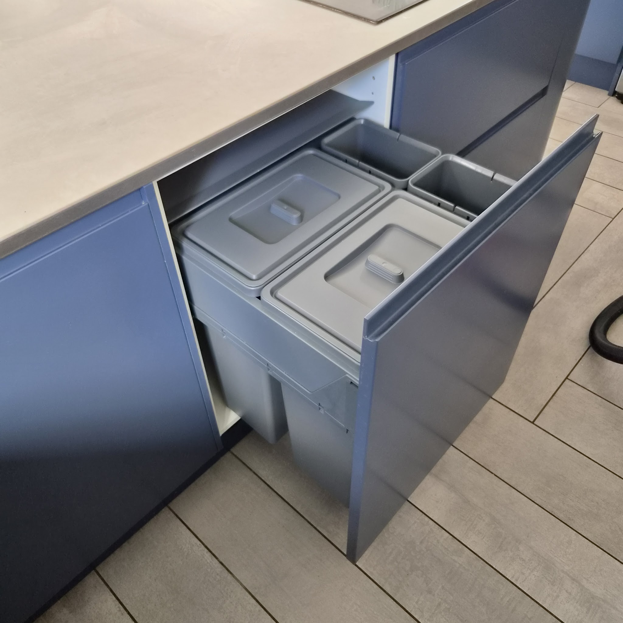 Navy handleless drawer pulled out to show built-in recycling bins